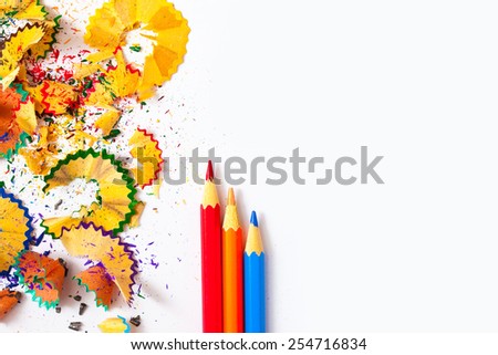 set of colored pencils and shavings on white background with copy space.