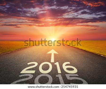 Driving on an empty road towards the setting sun to upcoming 2016 and leaving behind old 2015. Royalty-Free Stock Photo #254745931