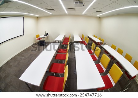Tables and chairs in an empty classroom. Fish-eye photo
