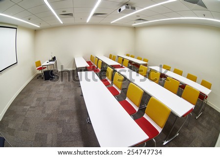 Tables and chairs in an empty classroom. Fish-eye photo