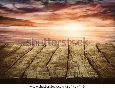 Wood table and tropical sunset landscape in the background. Summer background. Holiday