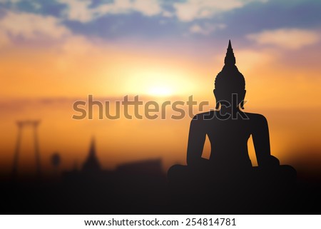 Vesak day concept: Silhouette Buddha with blurred travel tourist attraction in Thailand - Asia on golden temple sunset background