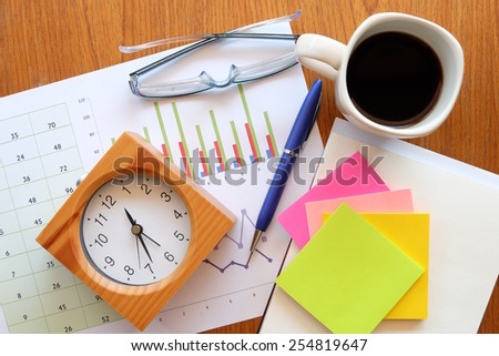 calculator and chart on the wooden table with back coffee  