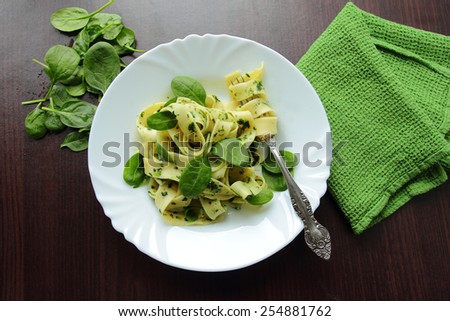 White plate with tagliatelle pasta with fresh spinach