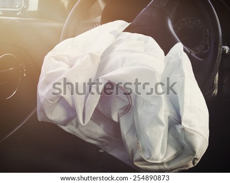 A front car airbag has deflated in a steering wheel from an accident. Use it for a safety or insurance concept. Royalty-Free Stock Photo #254890873