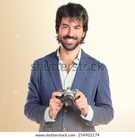 Man photographing over ocher background