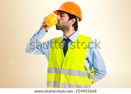 Workman holding a cup of coffee 