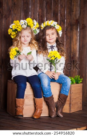 portrait of two little girls with Wreath from Flowers