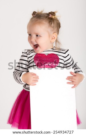 Smiling little girl behind empty white board