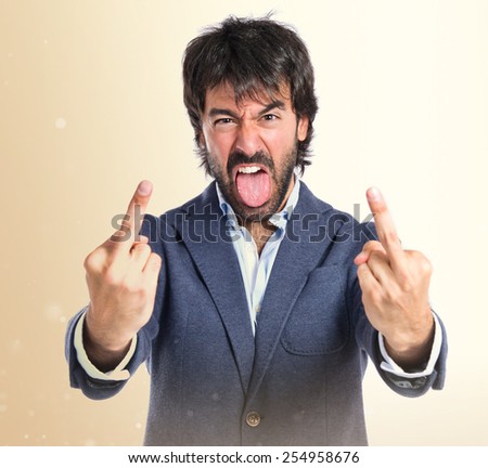 Man making horn gesture over white background
