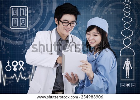 Male doctor with his partner using a digital tablet in front of the futuristic interface background