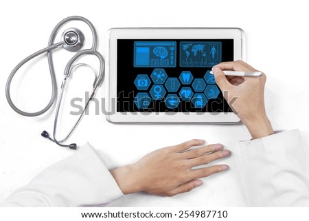 Closeup of medical doctor hands using a stylus pen to touch medical symbol on the tablet