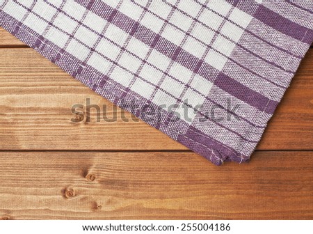Violet tablecloth or towel over the surface of a brown wooden table