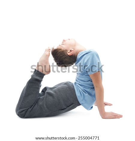Full shot of a caucasian 12 years old children boy in a blue t-shirt doing yoga or stretches. Composition isolated over the white background
