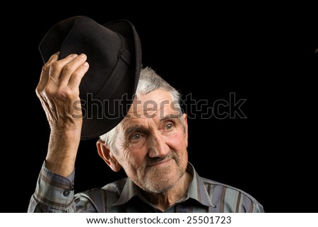 Old man saluting with his hat, isolated on black