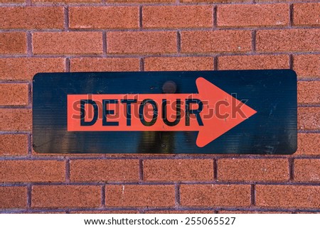 Detour sign on background of red brick wall pattern texture
