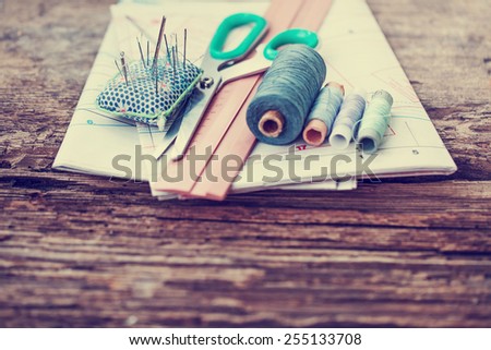Tools for sewing and handmade: thread, scissors, pins on brown paper./selective focus
