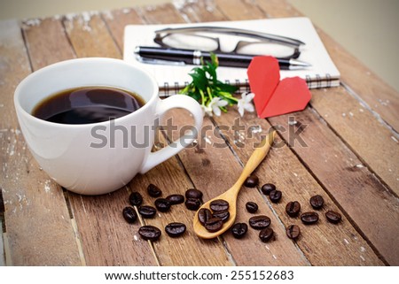 Cup of coffee and beans with notebook, flower, red heart shape
