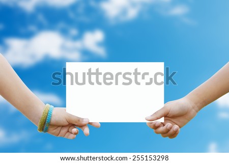Two children holding a white paper background blur sky.