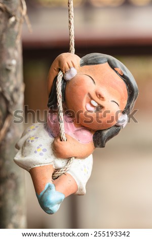 Smile clay doll hanging rope under the tree