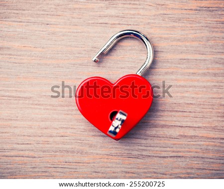 heart shaped opened lock on wooden background