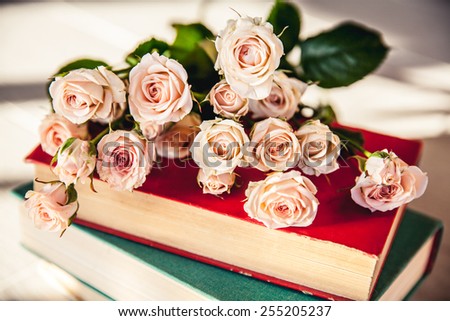 gentle roses with old books on a wooden background. flowers