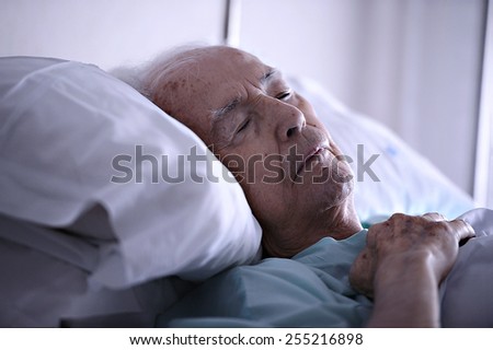 Old man sleeping in a hospital Royalty-Free Stock Photo #255216898