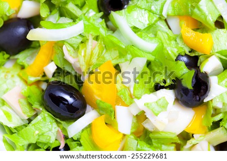 Assorted green leaf lettuce with squid and black olives. Close up