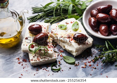 Feta cheese with olives and green herbs on gray marble background Royalty-Free Stock Photo #255256354