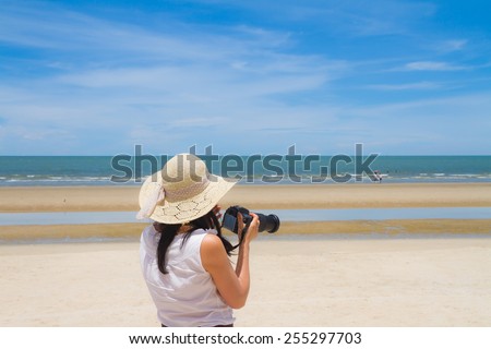 Woman with camera on the beach