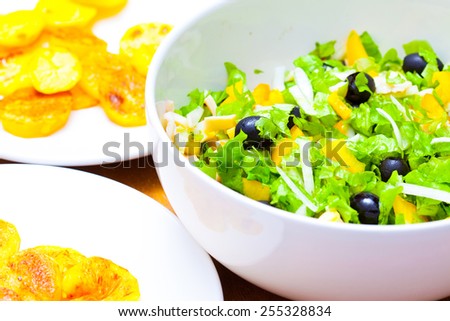 Assorted green leaf lettuce with squid and black olives, close up