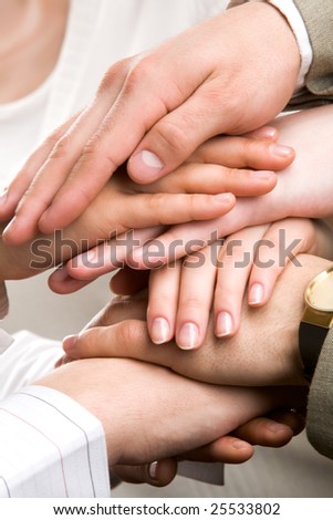 Symbol of companionship between business people shown by pile of their hands