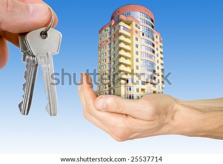 business and mortgage concept. hand with house and keys