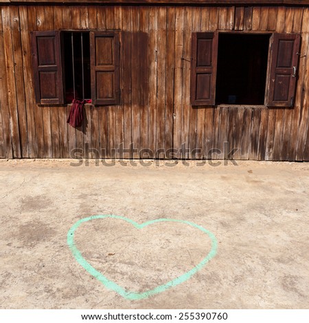 Heart drawn by chalk on the ground near wooden temple