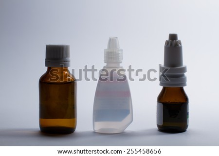 Three different vials of eye drops, nasal drops, and drops to the cores.