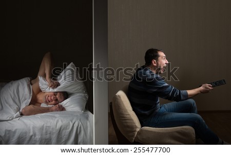 Man at night can't fall asleep because of the noisy neighbor Royalty-Free Stock Photo #255477700