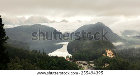 Lovely landscape picture in the South of Bavaria, Germany. September Autumn Scenery with view on the Mountains, a lake and a medieval castle near Munich