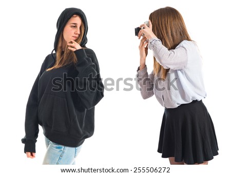 Girl photographing at her twin sister