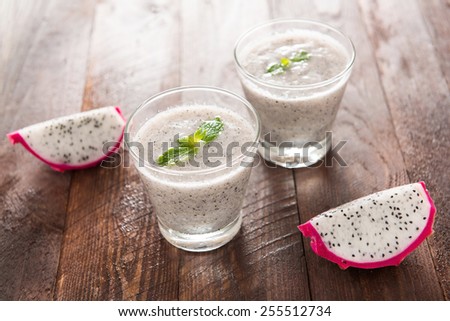 Dragon fruit smoothie on wooden table.