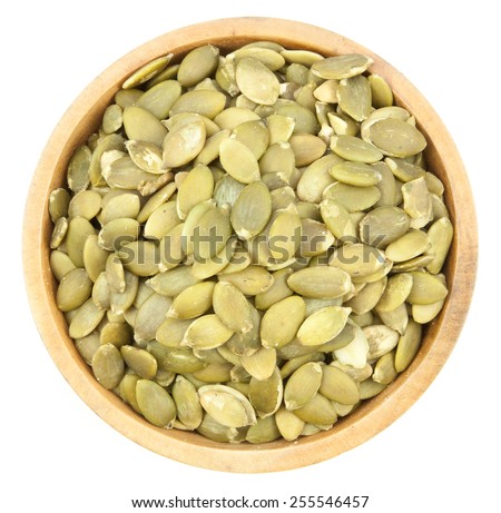 Pumpkin Seeds  in a wood bowl  isolated on white background