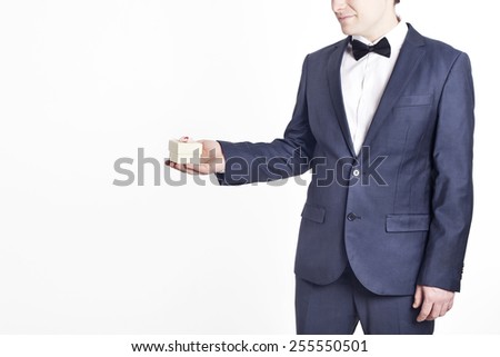 Business man with gift (Horizontal image). A businessman offering a gift to you (selective focus). Woman's day gift.