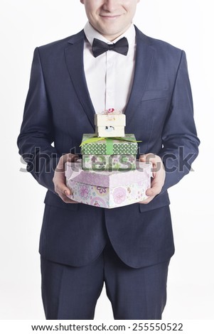 Business man with gifts (vertical image). A businessman offering a gift to you (selective focus).