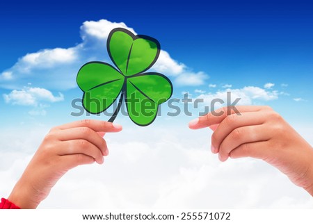 Shamrock against bright blue sky with clouds