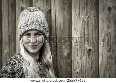 Beautiful blonde female stay uoutdoor on the wood background