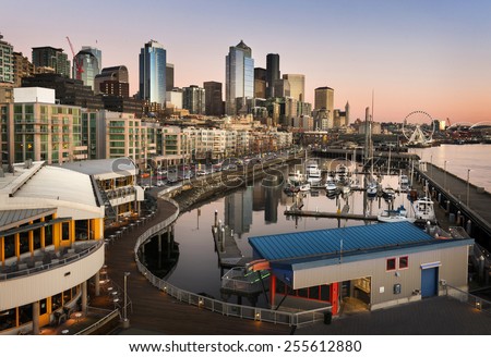 Seattle Waterfront at Sunset. The Seattle, Washington waterfront and skyline at sunset with a marina and ferris wheel. The Port of Seattle can be seen in the background.