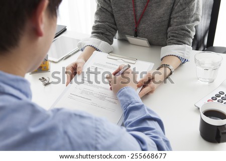 Young man signing financial contract