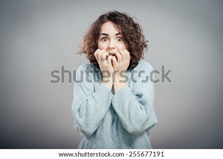 Closeup portrait  woman biting her fingernails craving for something or anxious, isolated grey wall background. Negative human emotions facial expression feeling Royalty-Free Stock Photo #255677191