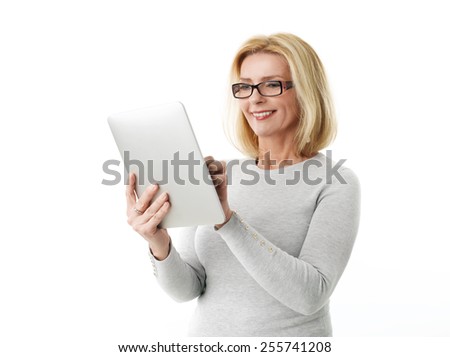 Close-up portrait of active business woman holding laptop while standing against white background.