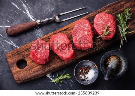 Raw fresh marbled meat Steak and seasonings on dark marble background Royalty-Free Stock Photo #255809239