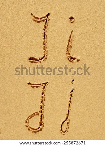 Concept or conceptual sand font or letter set group or collection carved on exotic beach near sea isolated on a sandy background, metaphor to nature, natural, education, character, message or summer